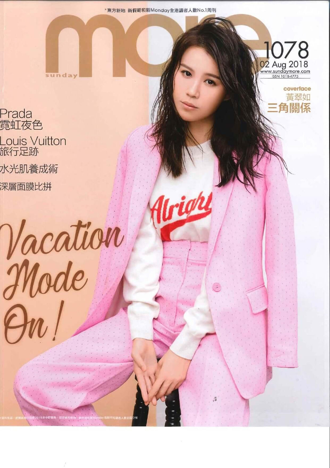 Woman in a pink polka dot suit and white sweater on magazine cover, fashion editorial style