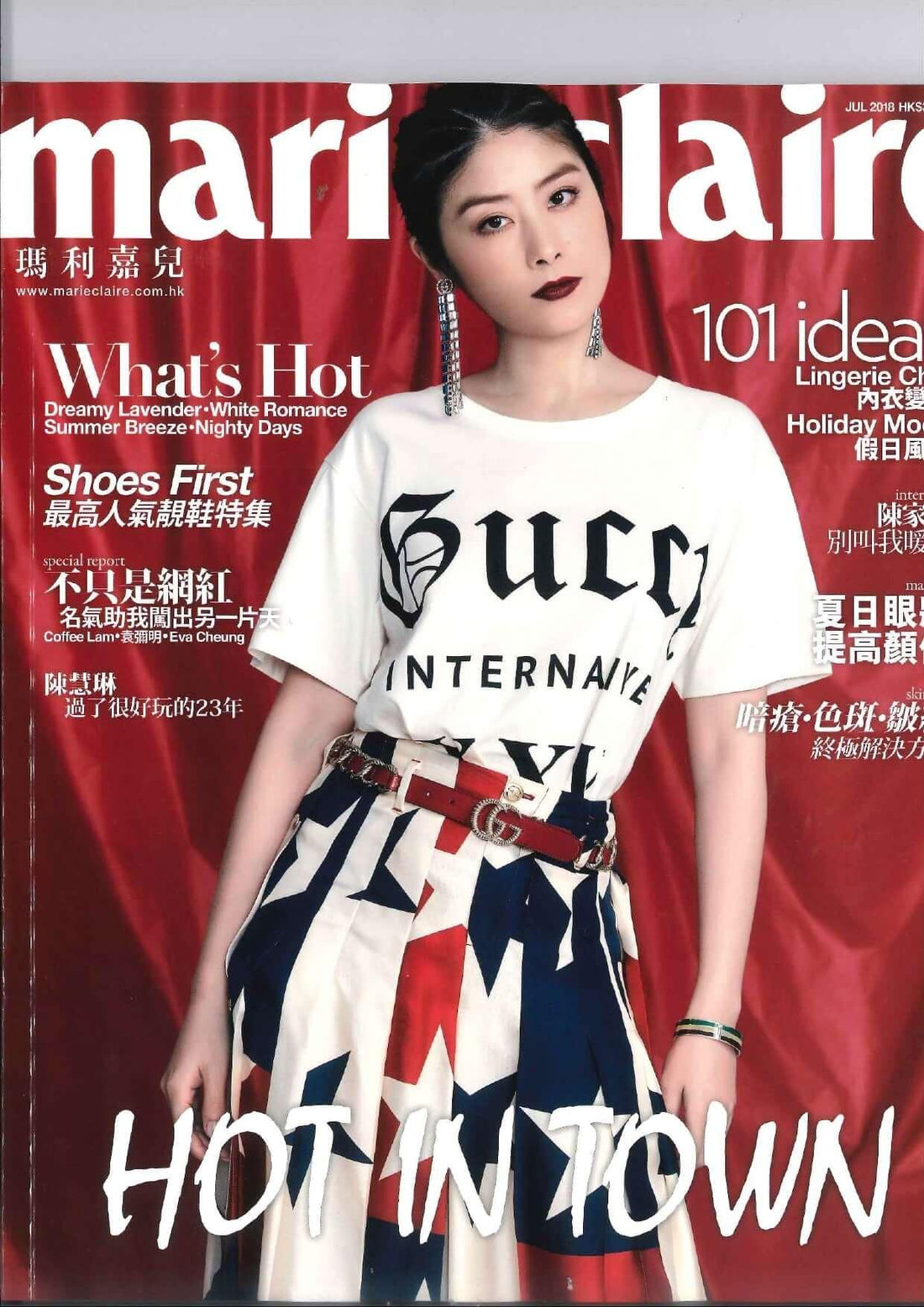 Woman in white graphic t-shirt and star-print skirt posing on a magazine cover