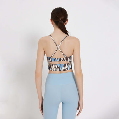 Back view of a woman wearing a Soft Splash Bra Top with crisscross straps and blue leggings.