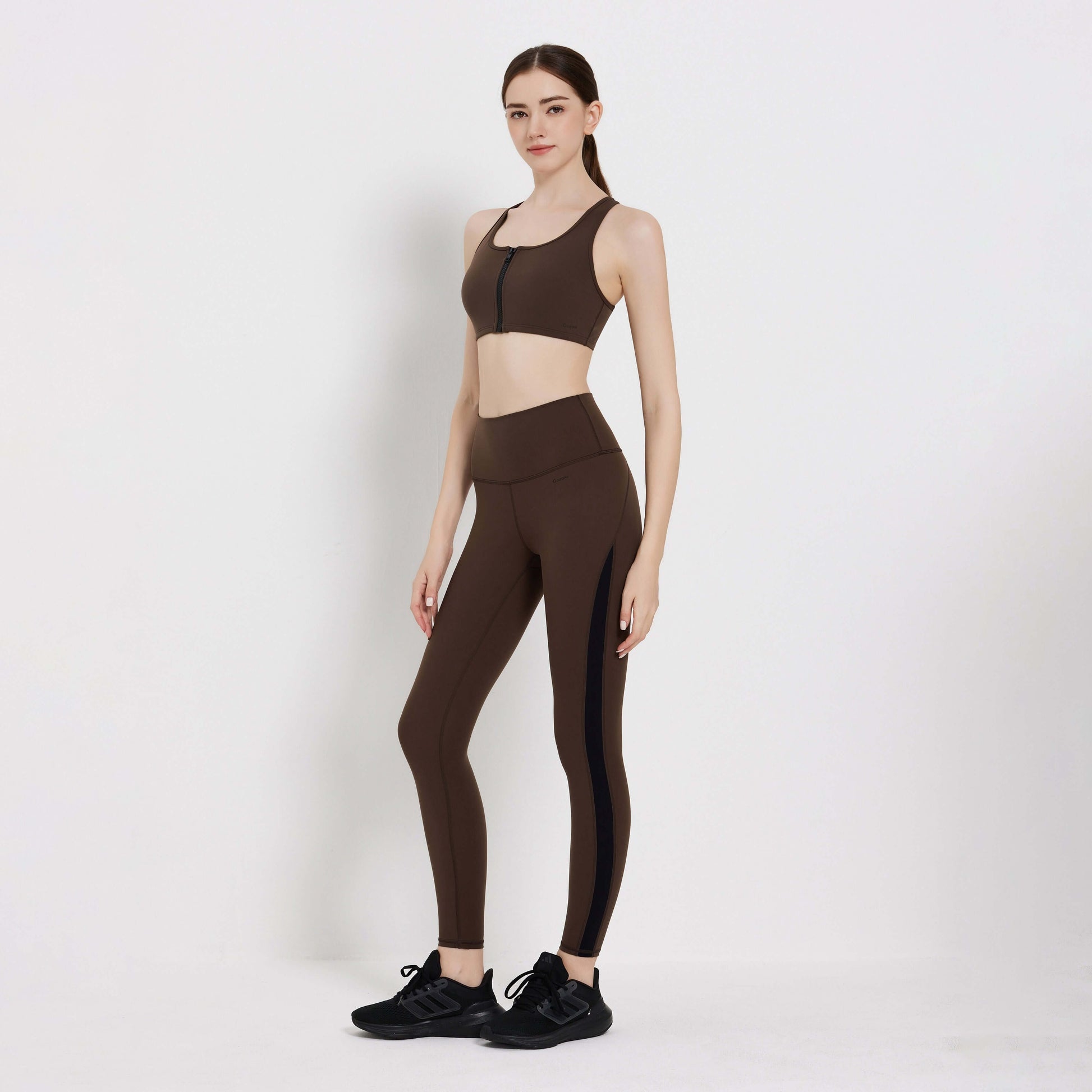 Model wearing Impact Legging in brown, styled with a matching sports bra and sneakers, showcasing activewear for fitness.