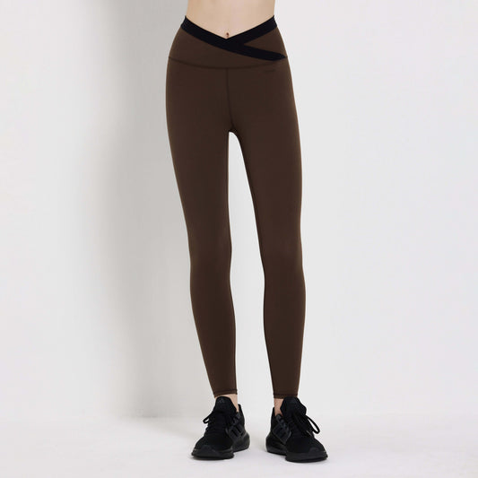 Brown Slash Legging with cross waistband, ideal for workouts and casual wear, paired with black sneakers.