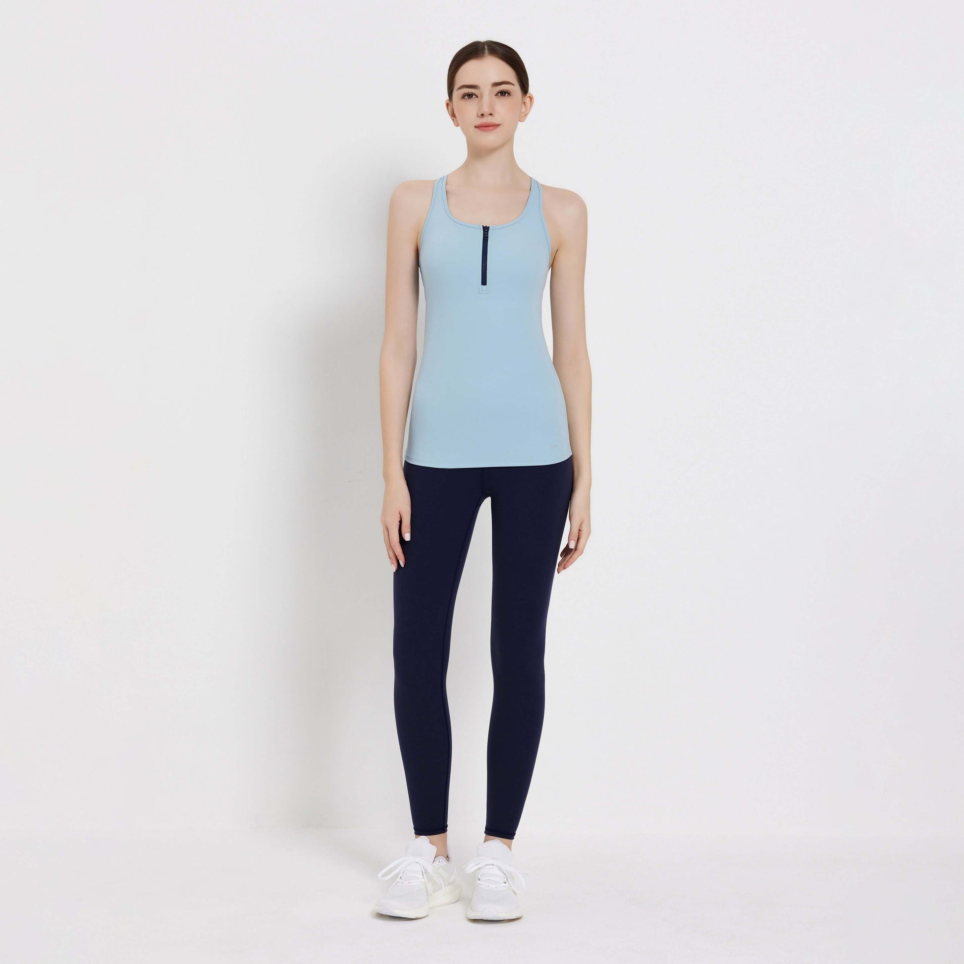 Model wearing a light blue Impact Tank Top paired with navy leggings, perfect for workouts or casual outings.