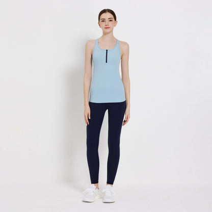 Model wearing a light blue Impact Tank Top paired with navy leggings, perfect for workouts or casual outings.