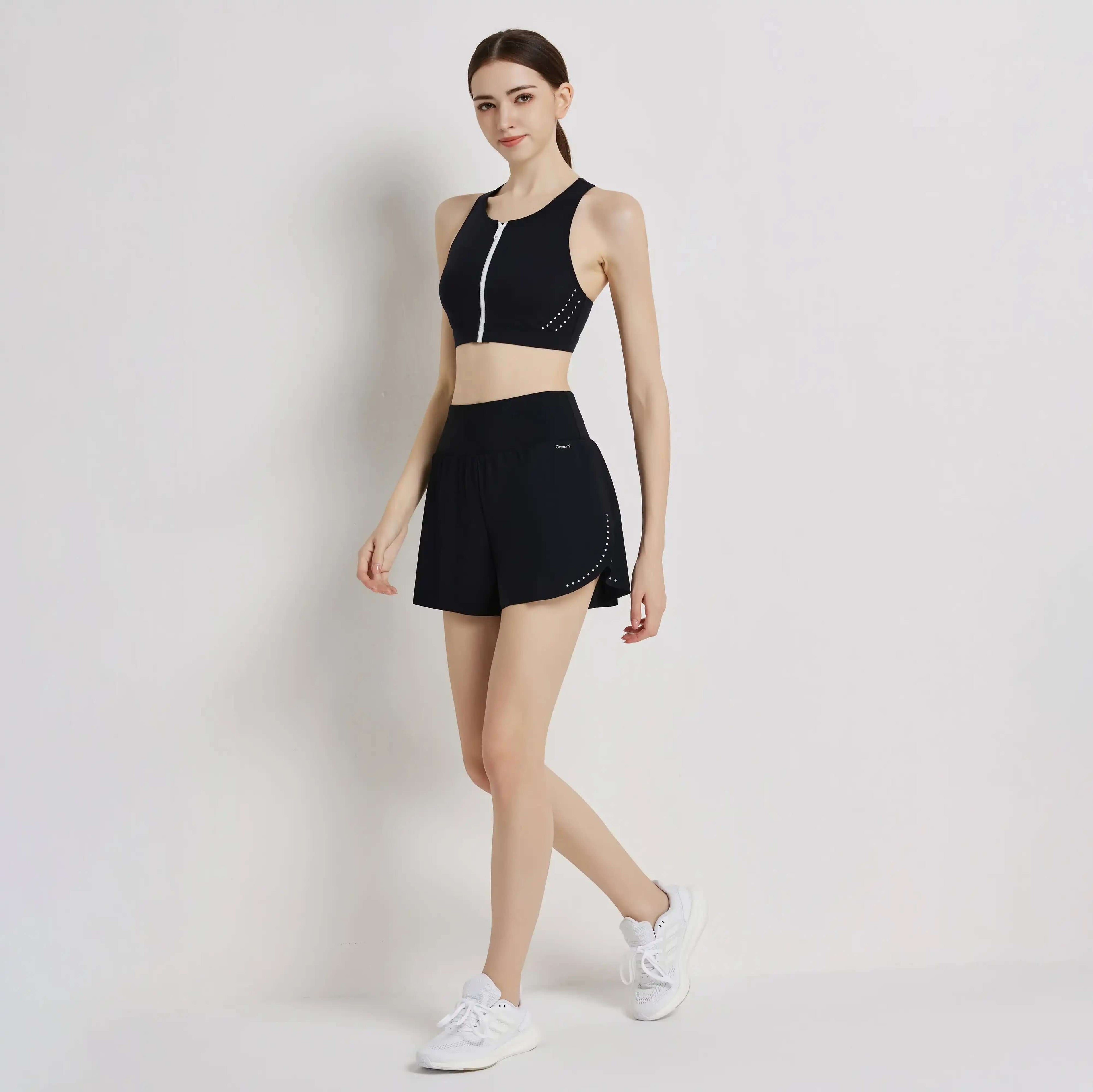 Woman modeling black zip-up sports bra and running shorts activewear set