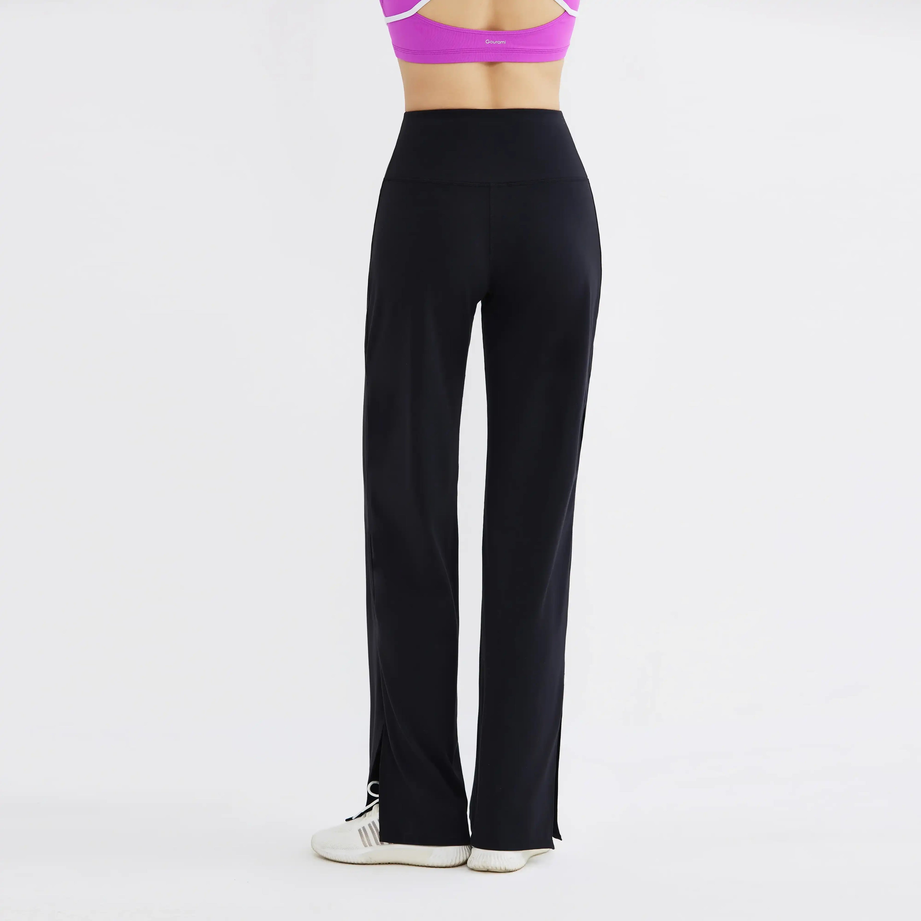 Black high-waisted flared yoga pants on model, shown from back, activewear style