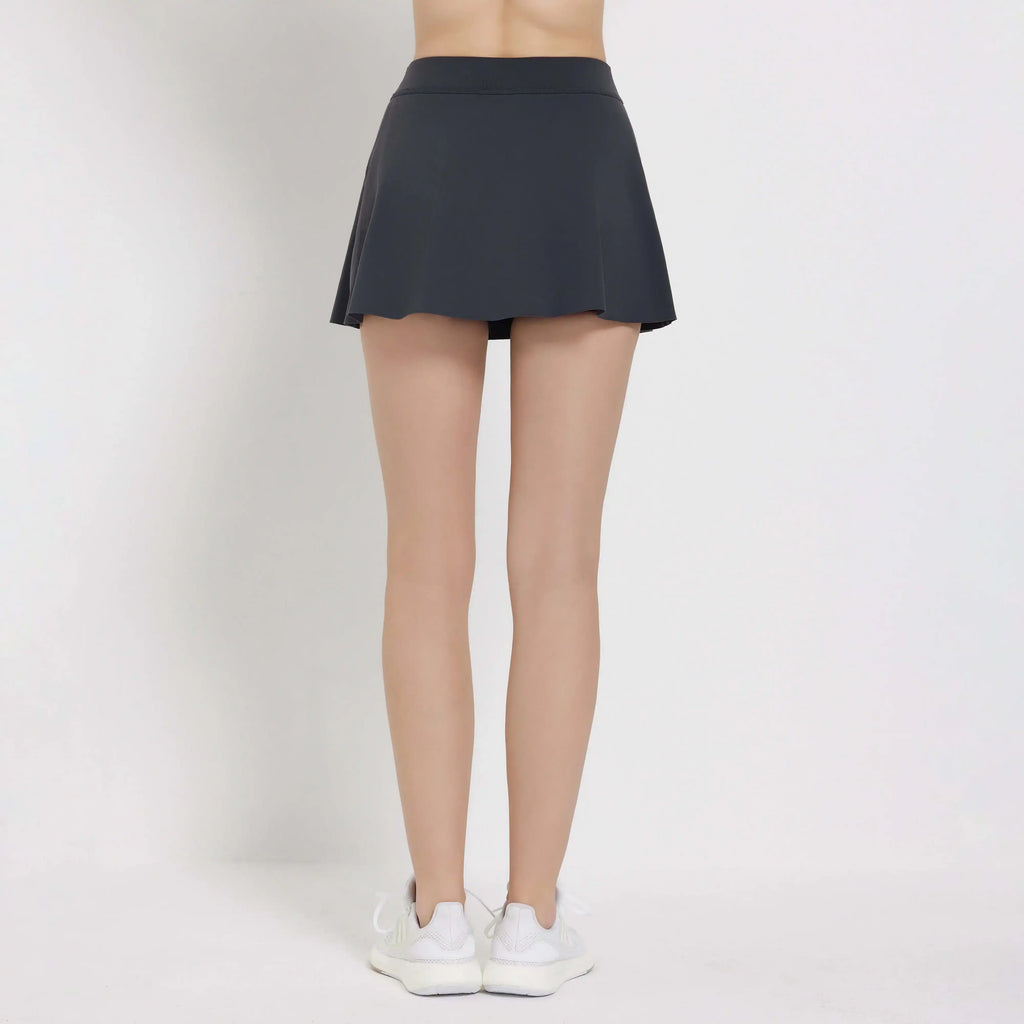 Back view of a woman wearing a stylish Balance Skort in dark grey, perfect for sport and casual outings.