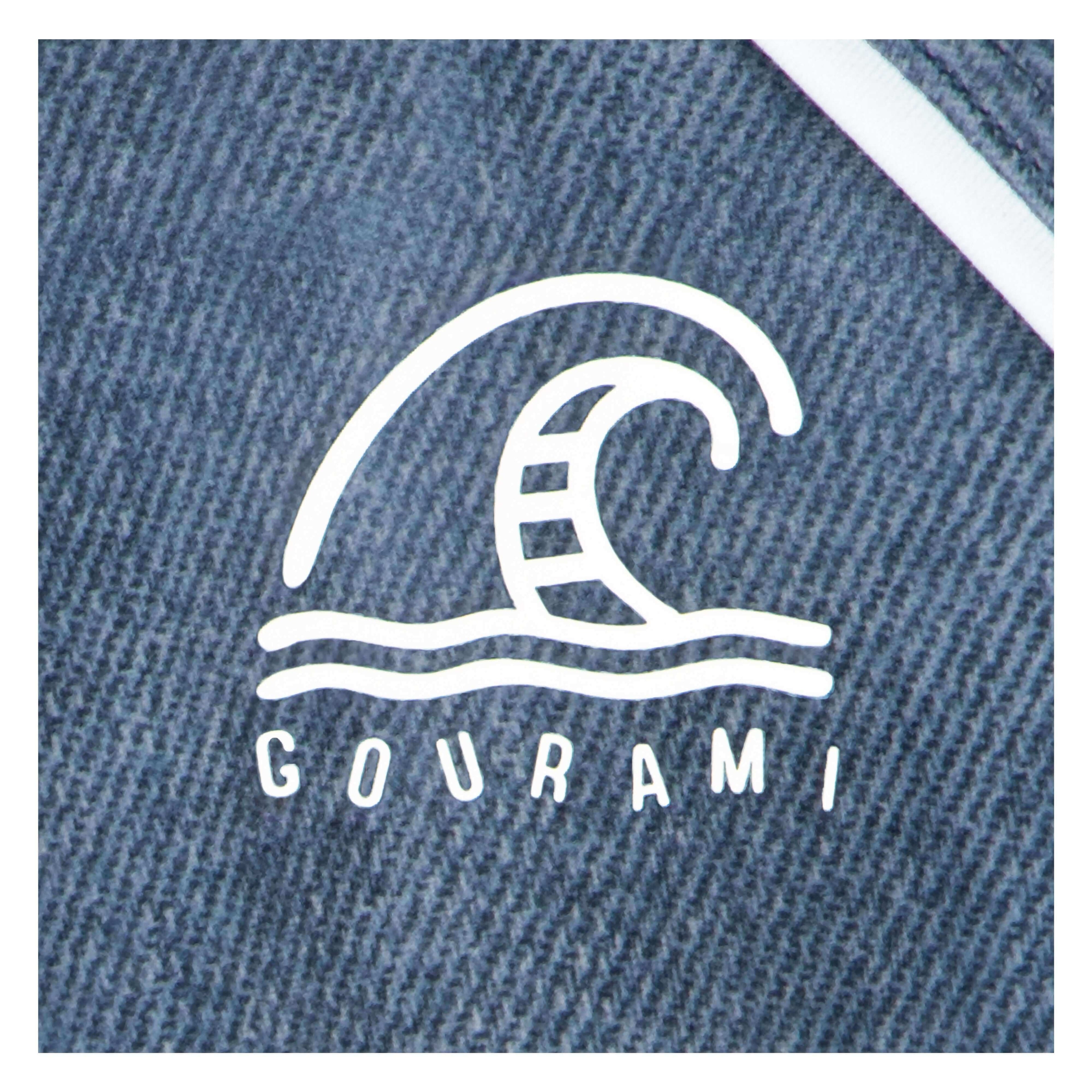Gourami brand logo on blue activewear fabric, featuring wave design for swimwear and gym apparel