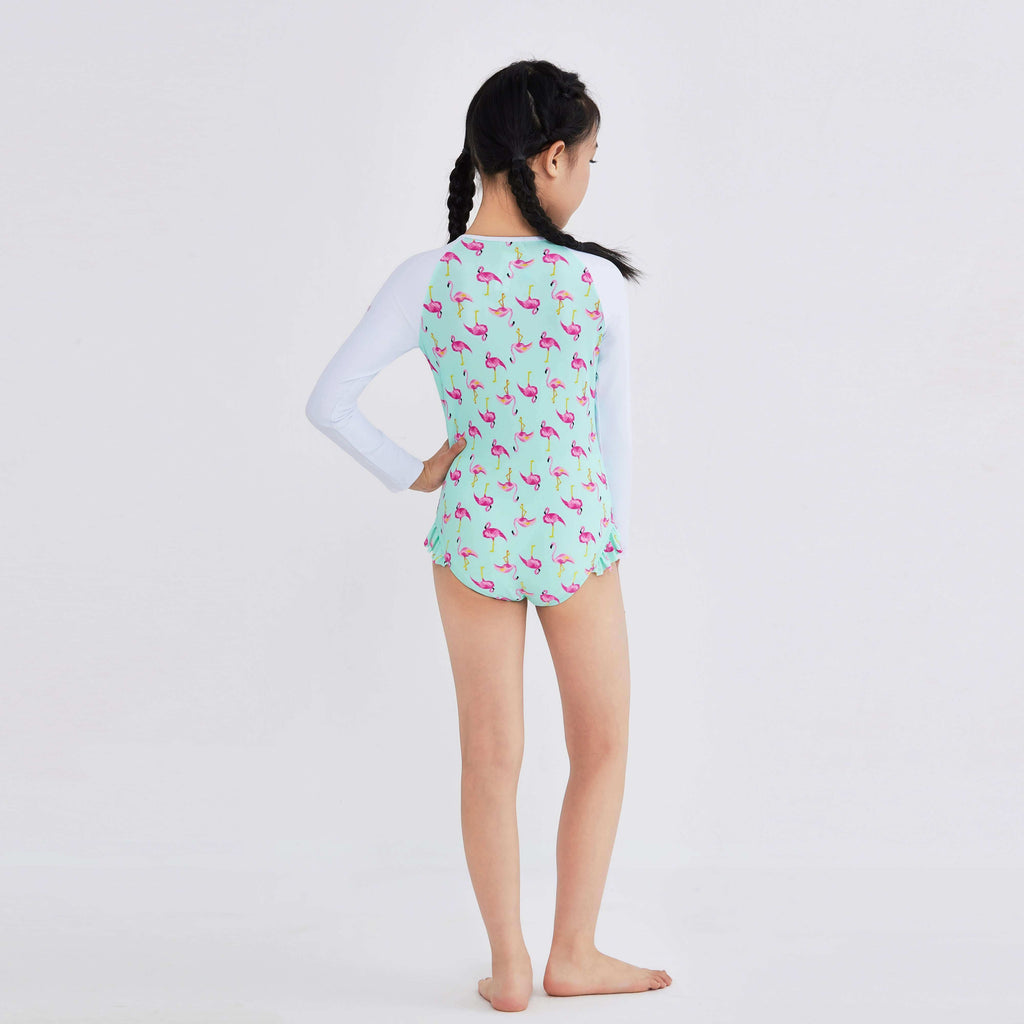 Girl in mint green flamingo print long-sleeve swimwear with ruffle hem, back view