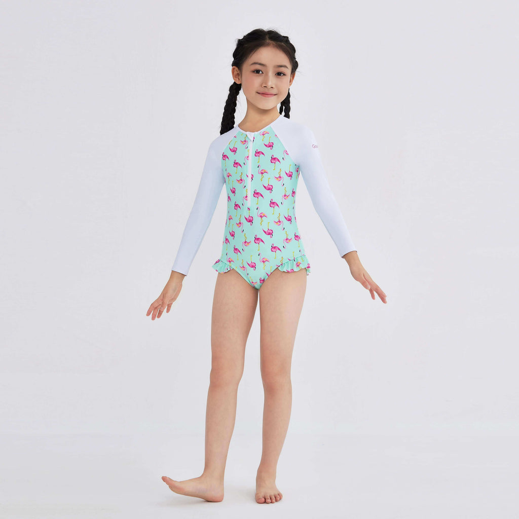 Girl in flamingo print swimwear with long sleeves and ruffle hem, designed for active movement.