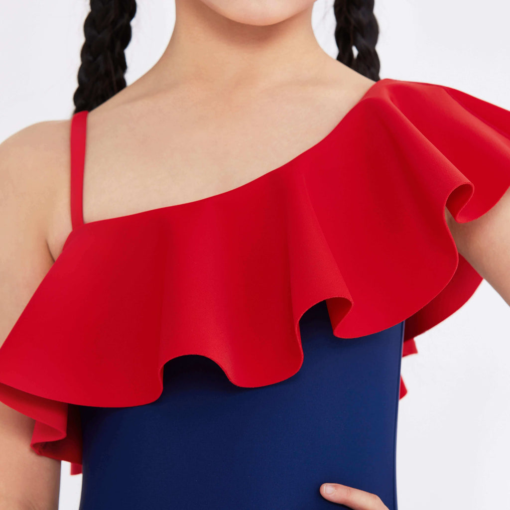 Red ruffle one-shoulder swimwear top with blue base, styled for active elegance.