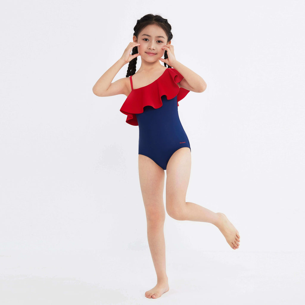 Girl in red and navy one-piece swimsuit with ruffle detail, designed for active movement and style.