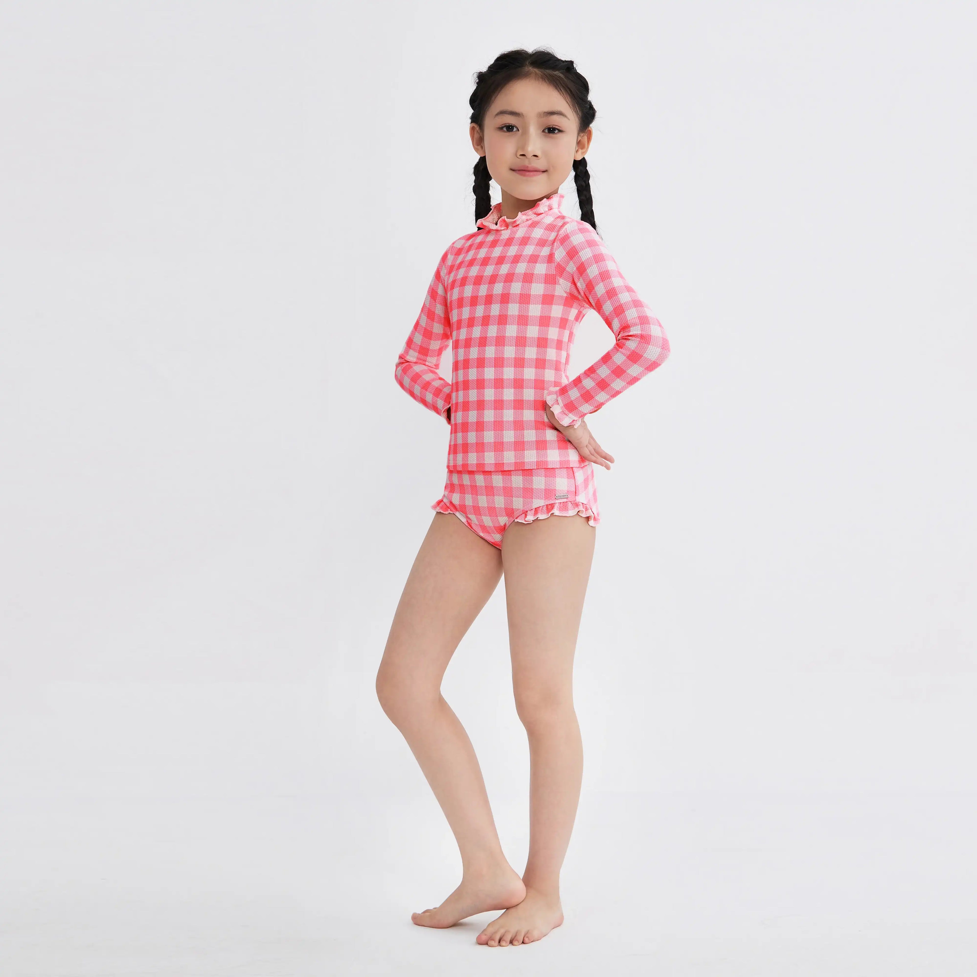 Girl in pink and white checkered long-sleeve swimsuit with ruffled details