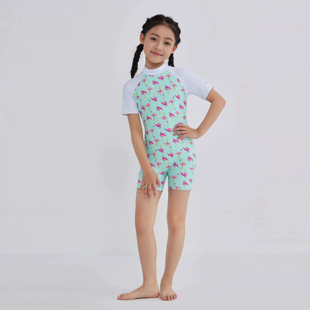 Girl in mint green flamingo print rash guard swimwear with white sleeves, designed for active water play.