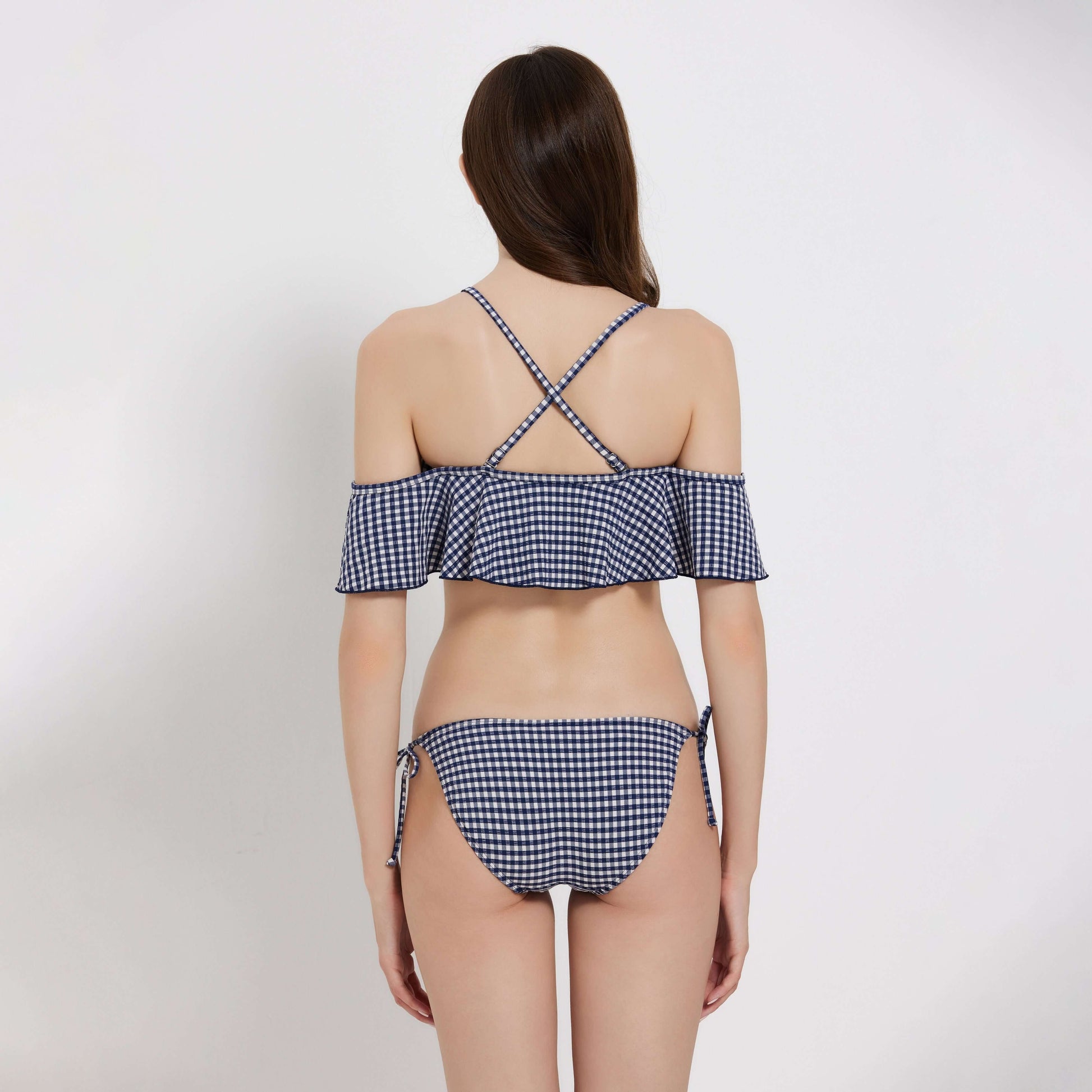 Stylish Gingham ladies bikini featuring ruffle details and cross-back straps, perfect for summer outings.