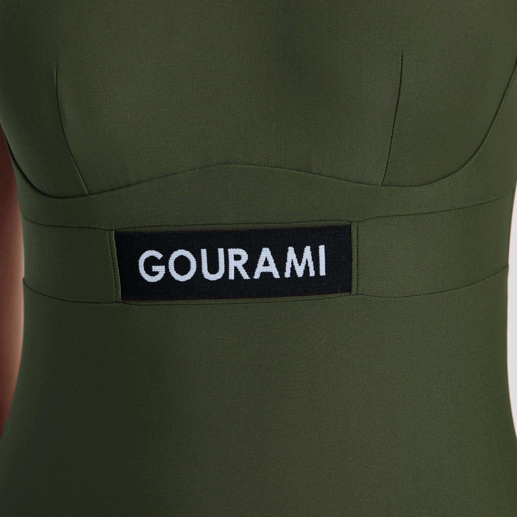 G Sport 泳衣，采用橄榄绿面料，配有时尚的黑色 GOURAMI 标签。