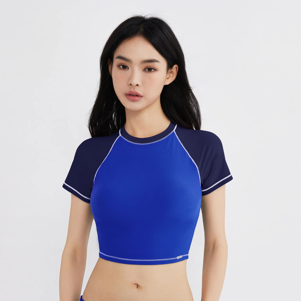 Blue and navy cropped swim top with white stitching for active women