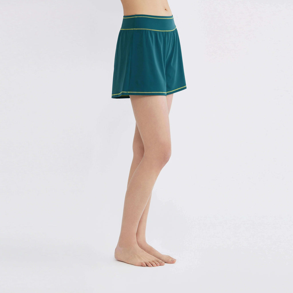 Teal activewear shorts with lime trim, designed for comfort and movement, perfect for swim or everyday wear.