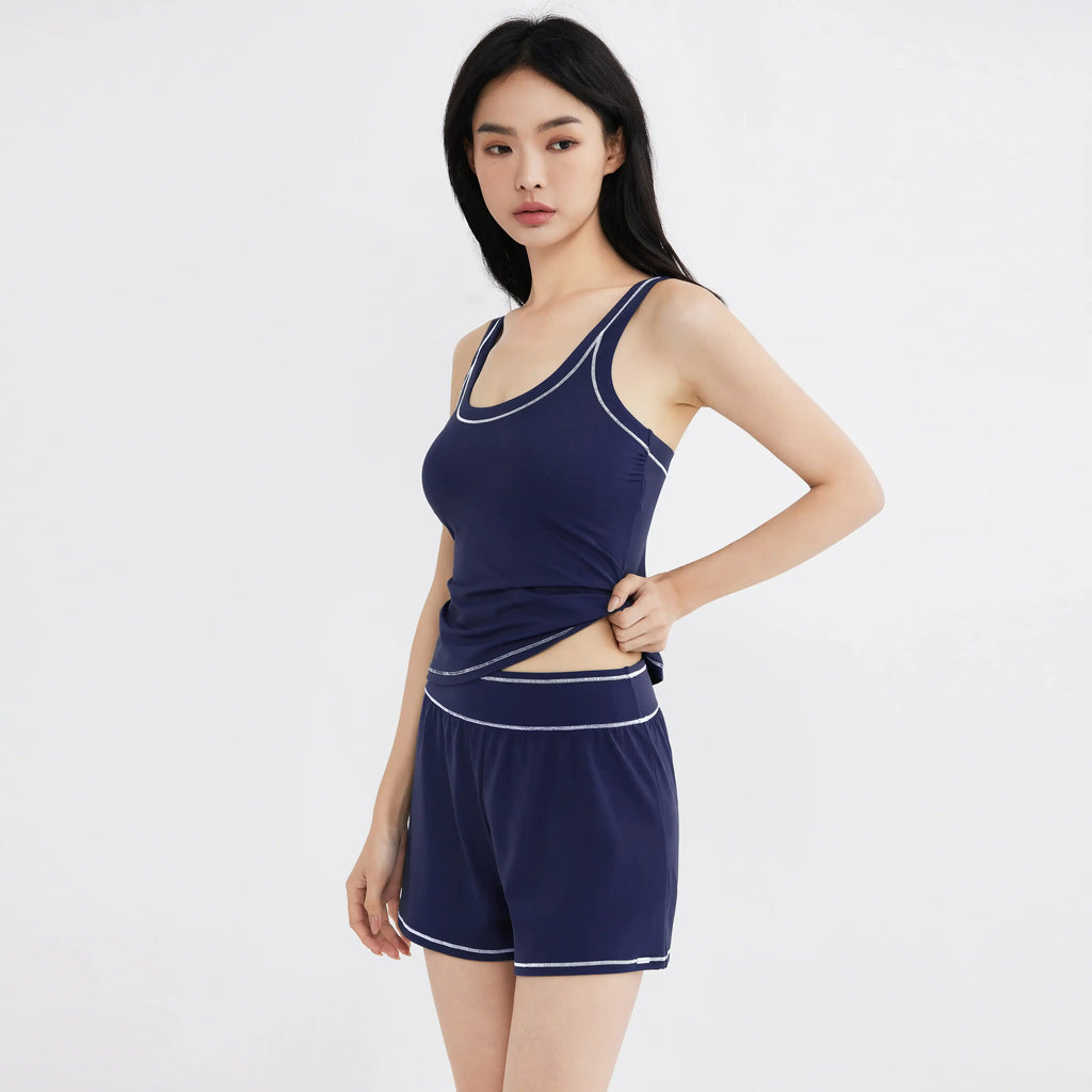 Navy blue activewear set with white trim, featuring a tank top and shorts for women, designed for comfort and movement.
