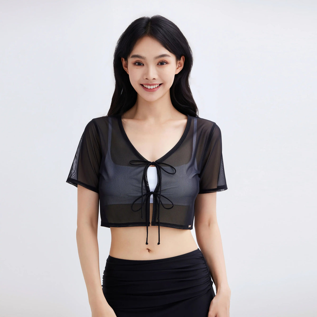Woman wearing a Gourami Drift black mesh cropped coverup top with tie-front detail.