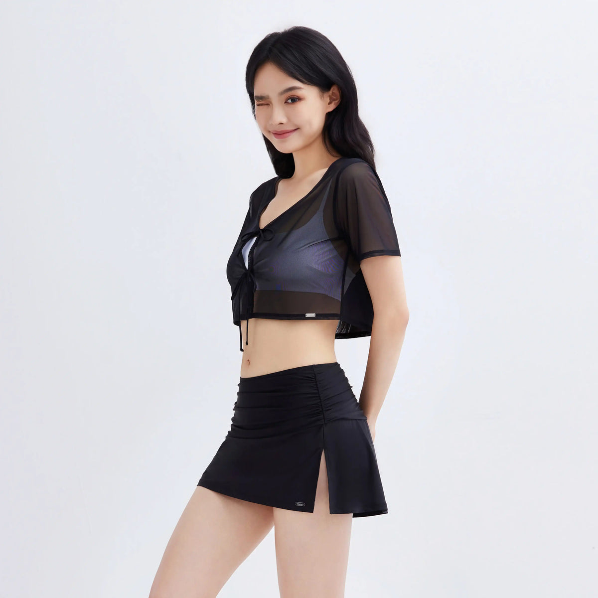 Woman wearing Gourami Drift Coverup Top in black sheer mesh with matching swim skirt.