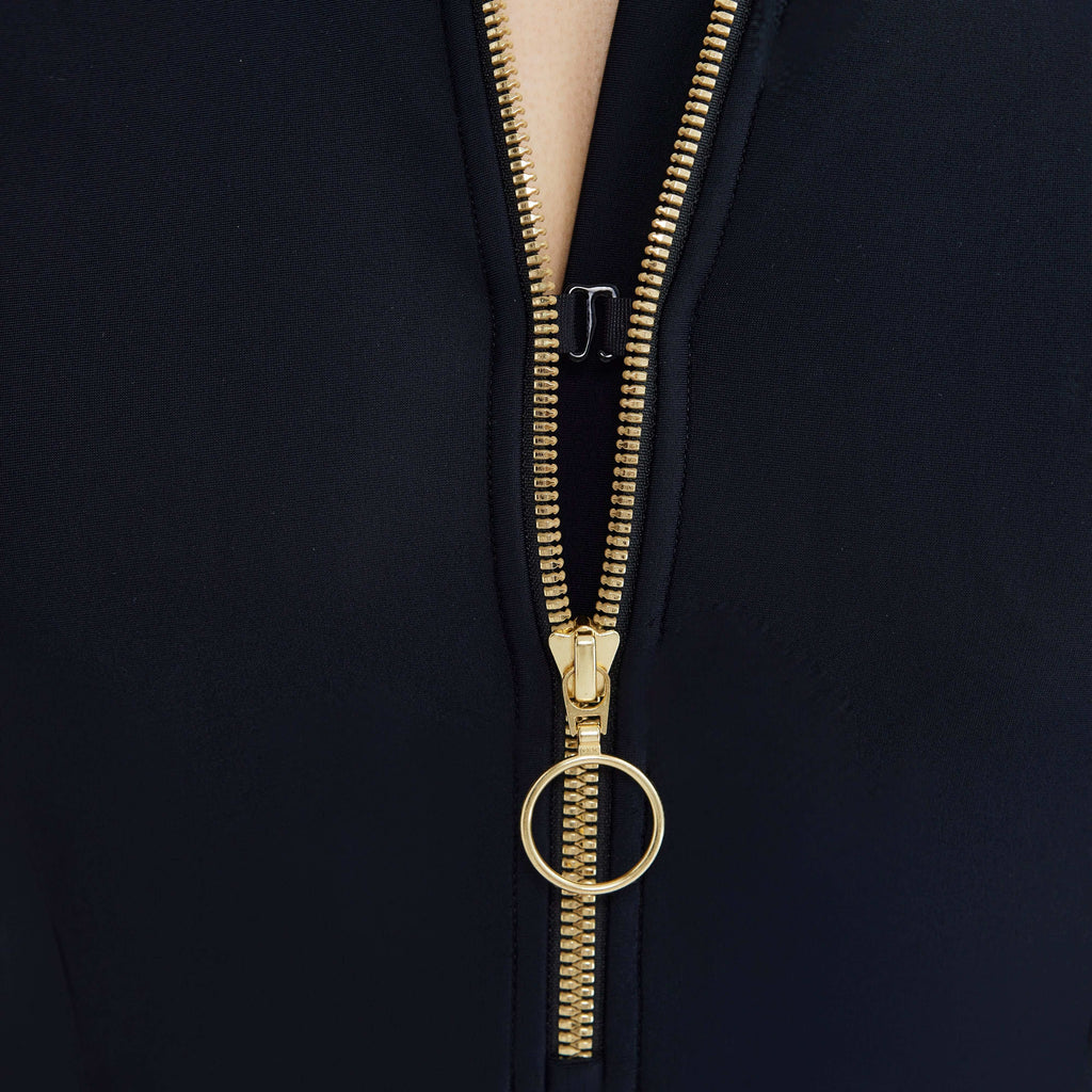 Black swimwear with gold zipper detail, designed for real women's movement and style.