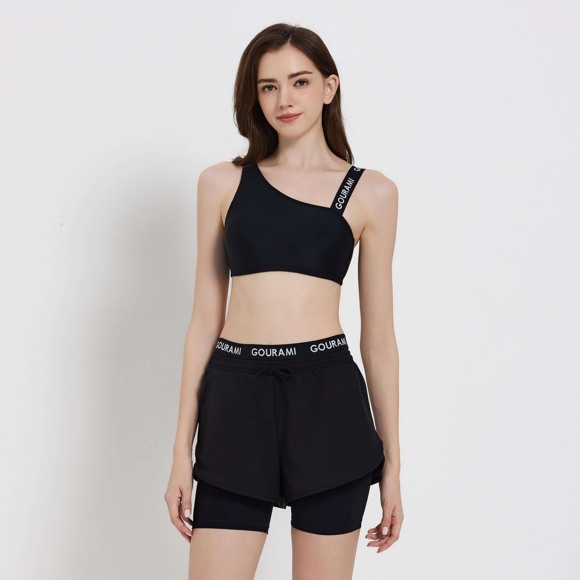 Gourami Band ladies boardshorts model wearing stylish black activewear, perfect for beach or casual outings.