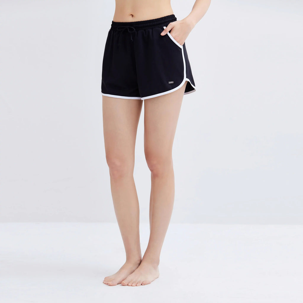Woman wearing black Contrasting Swim Shorts with white trim and drawstring waist.