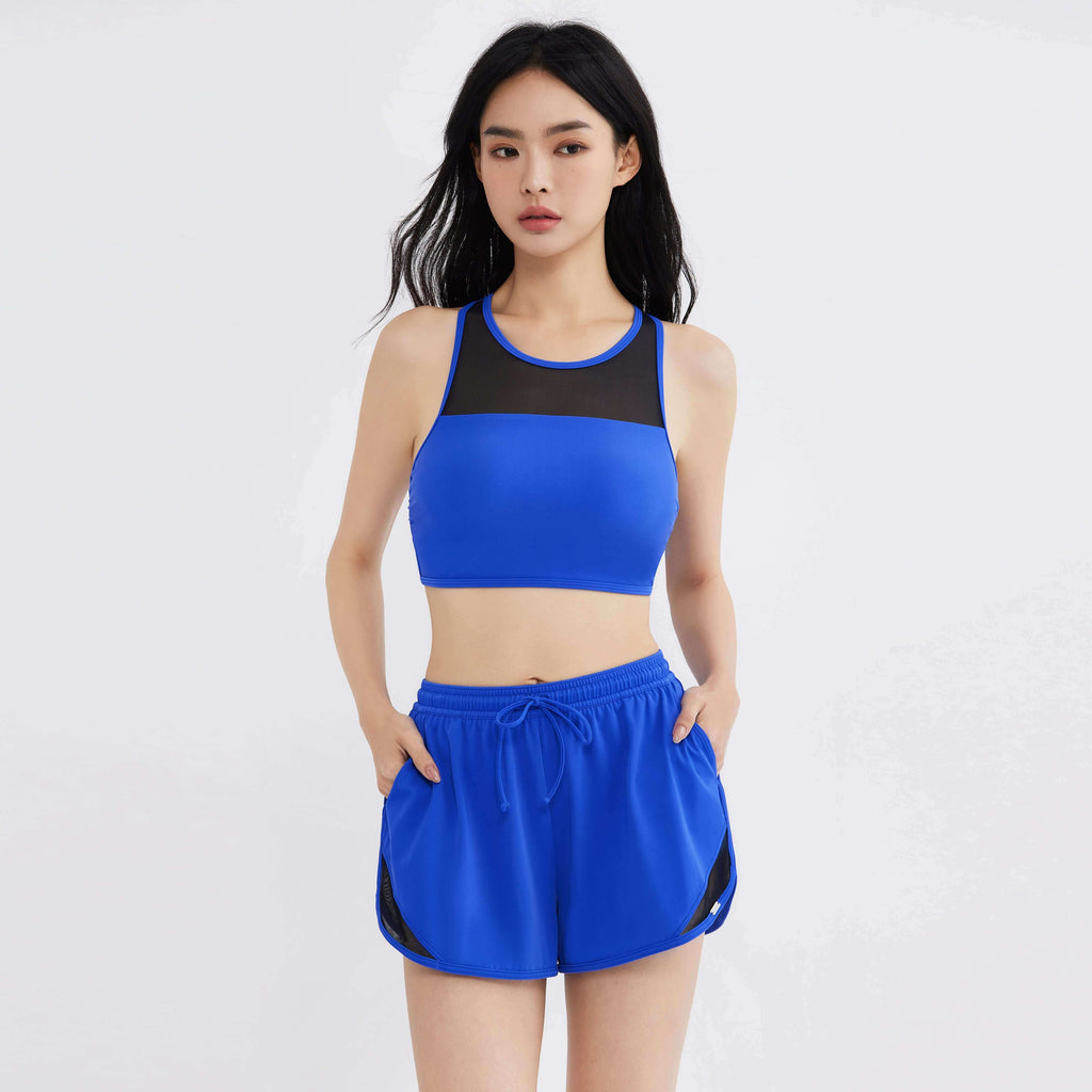 Woman in blue activewear set with mesh panels, designed for comfort and movement
