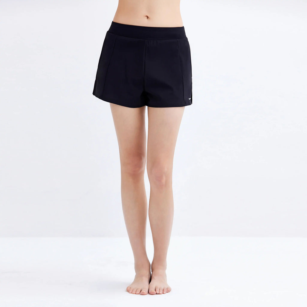 Woman wearing black Gourami Drift Gym to Swim Shorts against a plain white background.