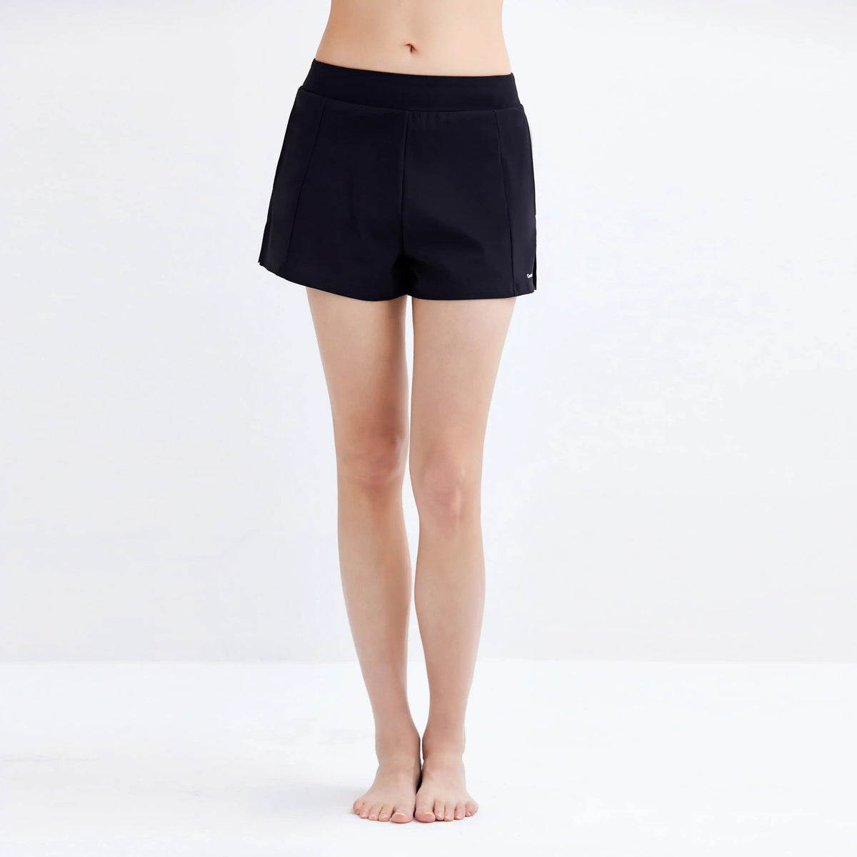 Woman wearing black Gourami Drift Gym to Swim Shorts against a plain white background.