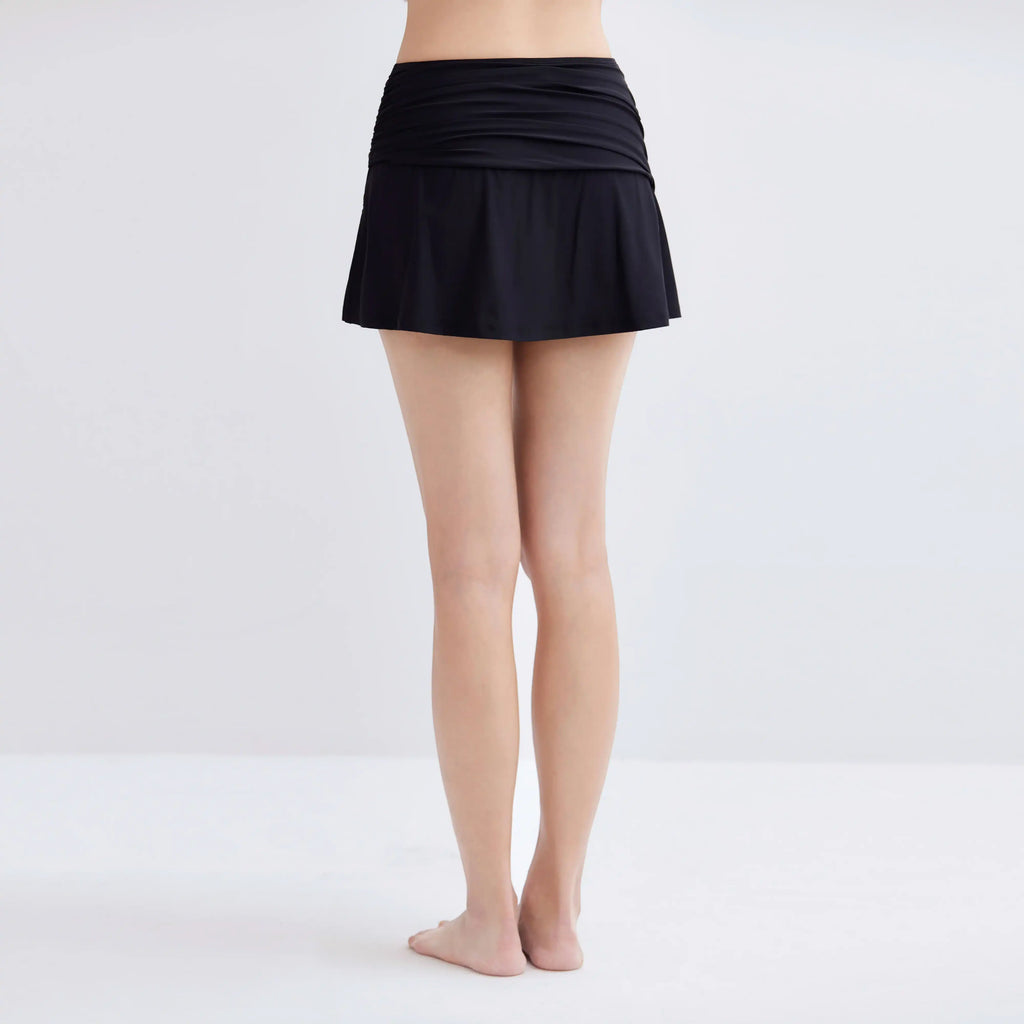 Back view of a woman wearing a black Gourami Tuck Swim Skirt.
