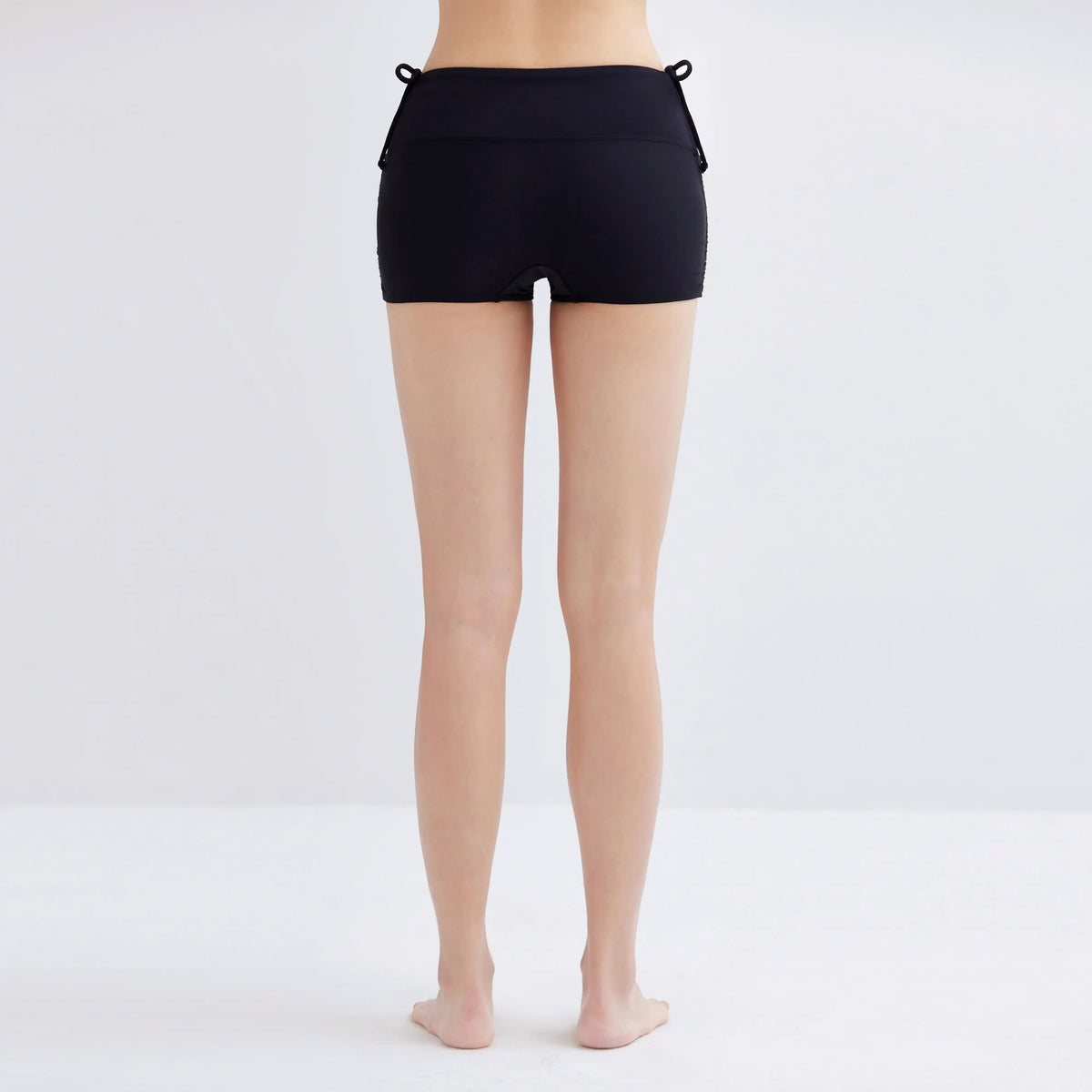 Back view of a woman wearing black Swim Fit Ladies Scrunchie Shorts.
