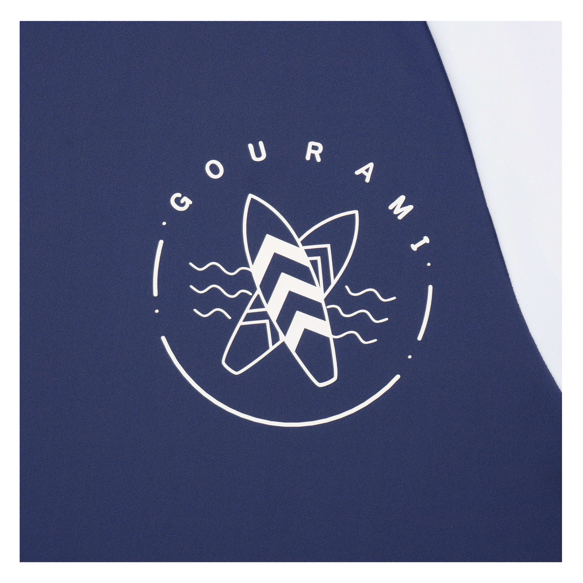 Close-up of the Gourami logo on a blue ocean men's rashguard, featuring surfboard design and wave elements.