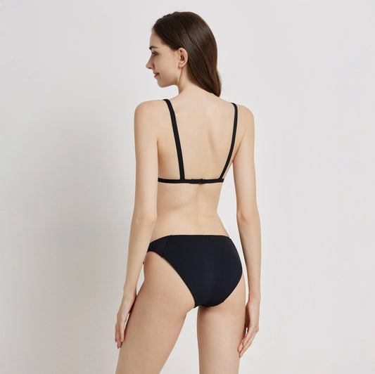 Model showcasing the back view of the Cascade Bikini, featuring minimal straps and a sleek design.