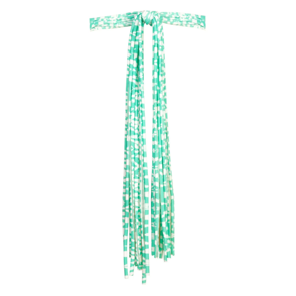 Green and white patterned swimwear tie straps with long, draping fabric, isolated on white.